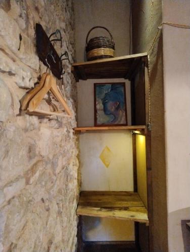 un estante en una pared con una foto y una cesta en Sasso Erminia R&B Ecosostenibile en Novafeltria