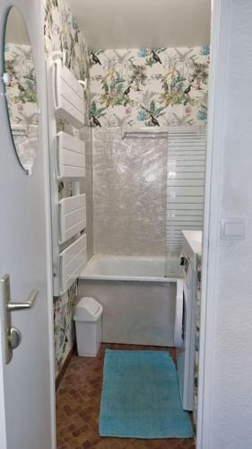 une petite salle de bain avec une baignoire et un lavabo dans l'établissement Logis des Palmiers YourHostHelper, à Gruissan