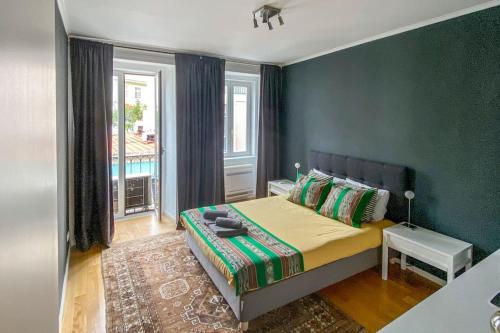 a bedroom with a bed with a green wall at Lisbon deluxe city center flat in Lisbon