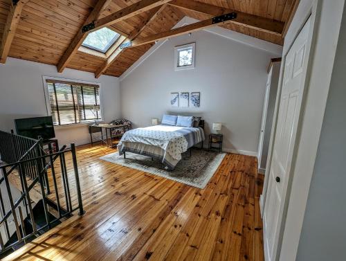 a bedroom with a bed and a wooden floor at Acadia Park Suites Condo in Southwest Harbor