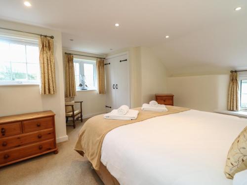 a bedroom with a large bed with two towels on it at 1 Rose Cottages in Looe