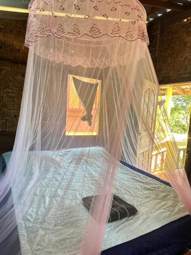 ein Bett mit einem Netz darüber in der Unterkunft Mama's Bungalows Koh Chang Ranong in Koh Chang Ranong