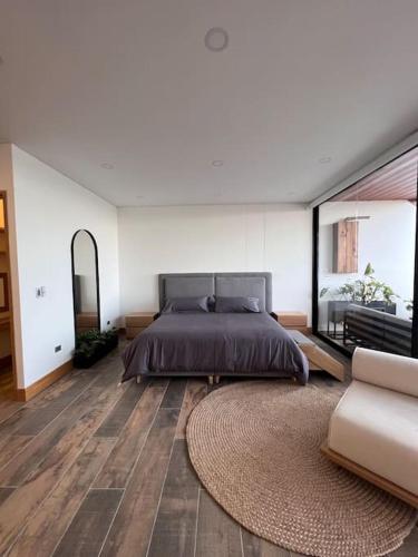 ein Schlafzimmer mit einem Bett und einem großen Teppich in der Unterkunft Modern Guatapé Loft with Starlink WiFi in Guatapé