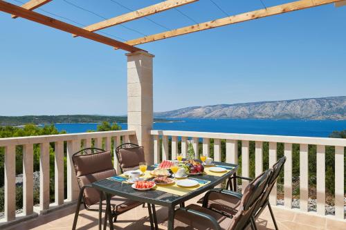 a table with food on a balcony with a view of the ocean at Doris Hvar in Rudina