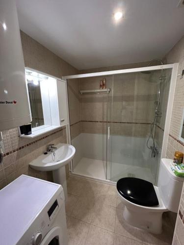 een badkamer met een douche, een toilet en een wastafel bij Roses Espagne 4/5 pers piscine - plage in Roses