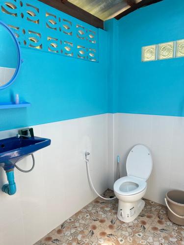 a blue bathroom with a toilet and a sink at Mama's Bungalows Koh Chang Ranong in Koh Chang Ranong