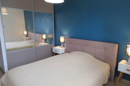 une chambre avec un lit blanc et un miroir dans l'établissement Villa idéale séjour en famille à Taussat, à Lanton