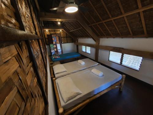 a small room with two beds in a cabin at Coleto Siargao in San Isidro
