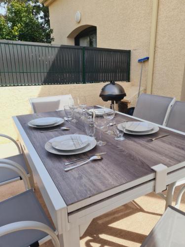 a wooden table with plates and wine glasses on it at tytoun evasion in Borgo