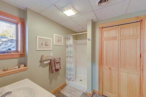 baño con ducha, lavabo y puerta en Spacious Harrison Cabin about 1 Mi to Long Lake!, en Bridgton