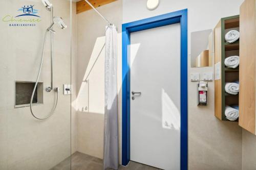 een douche met een blauwe deur in een badkamer bij Panorama Apartments Bergblick in Nußdorf