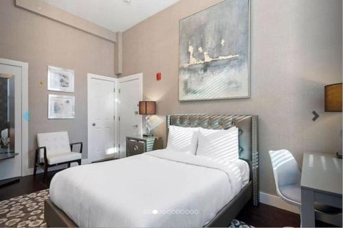 a bedroom with a large white bed and a desk at Premier Suites Bay Village in Boston