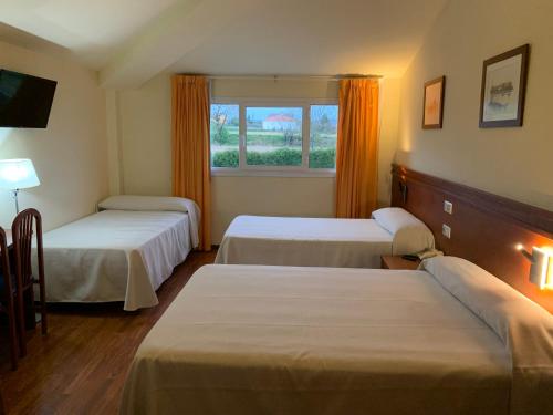 a hotel room with two beds and a window at Hotel Barreiro in Leira