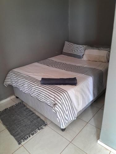 ein Bett in einem Schlafzimmer mit einer schwarzen und weißen Decke in der Unterkunft Letz Guest Lodge in Bochum
