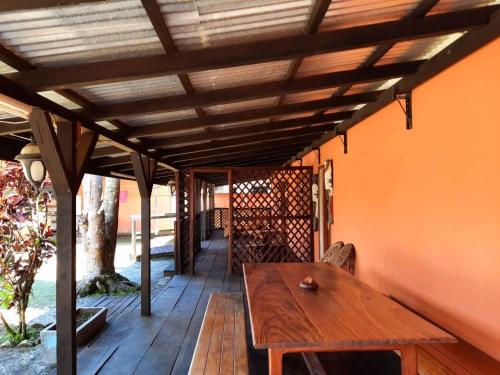 een houten tafel op een veranda met een houten dak bij residence des coeurs gabriella in Kribi