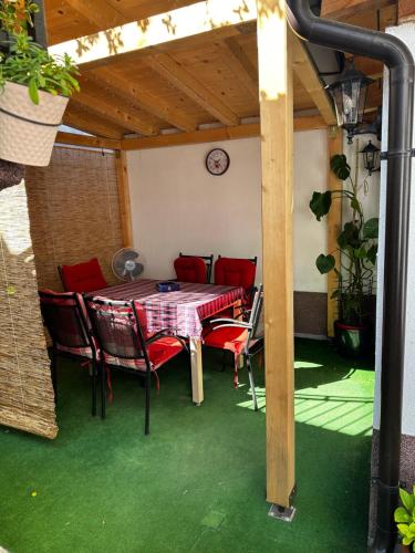 un patio con mesa y sillas bajo un techo en Guest House Nana, en Mostar