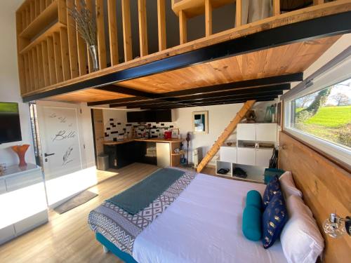 una camera da letto in una casetta minuscola con una grande finestra di Petit chalet a Nernier