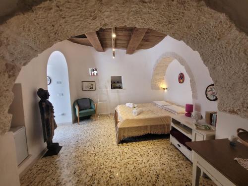 una camera con letto in una stanza con arco di Trulli La Cariola a Locorotondo