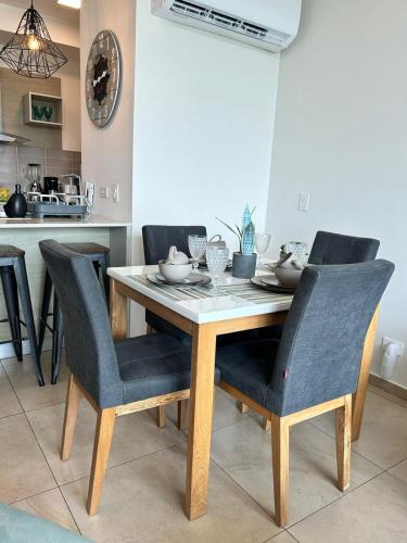 a dining room table with chairs and a table and a kitchen at Condo Gorgona Beach Apartamento de Lujo de 2 Habitaciones in Chame
