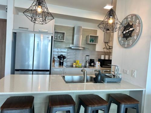 a kitchen with a sink and a counter with stools at Condo Gorgona Beach Apartamento de Lujo de 2 Habitaciones in Chame