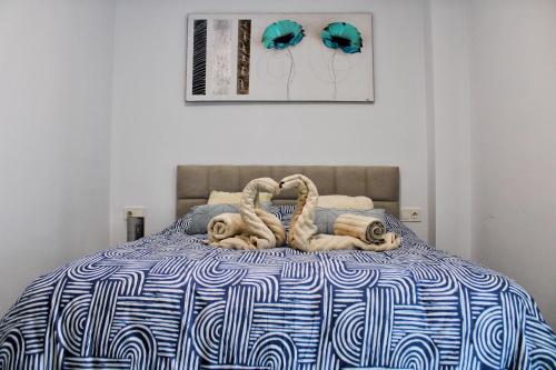 Un dormitorio con una cama con un edredón azul y blanco. en Calpe apartamento nuevo 1a línea playa piscina, en Calpe
