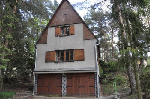 een klein huis met een gambrel dak bij Chata U Selské rokle in Doksy