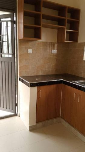 a kitchen with brown cabinets and a black counter top at Kasha's hideout 1 Sonde in Kasiyirize