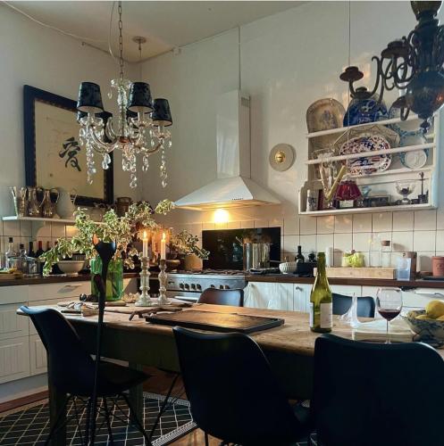 a kitchen with a large wooden table with chairs and a tableasteryasteryasteryastery at Jungshovedgaard Bed & Breakfast in Præstø