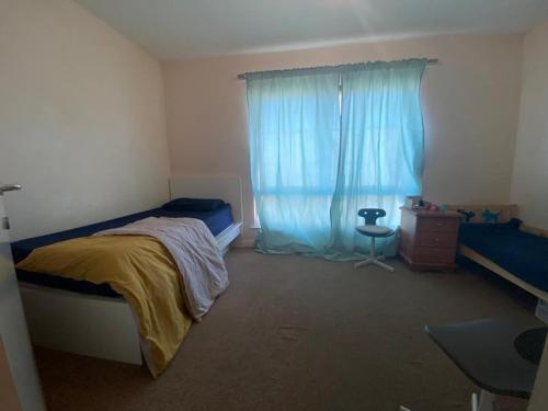1 dormitorio con cama y ventana azul en Self catered rooms en Thamesmead