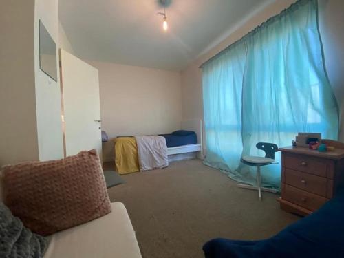 1 dormitorio con cama y cortina azul en Self catered rooms en Thamesmead