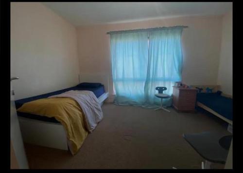 a bedroom with a bed and a blue window at Self catered rooms in Thamesmead