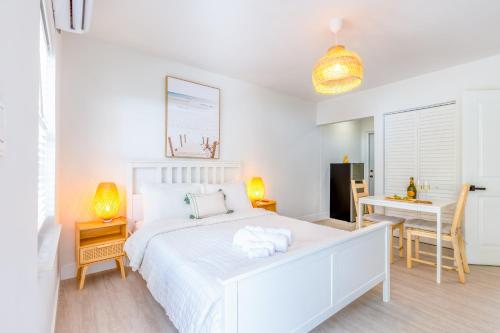 a white bedroom with a white bed and a desk at Casa Agave Miami in Miami