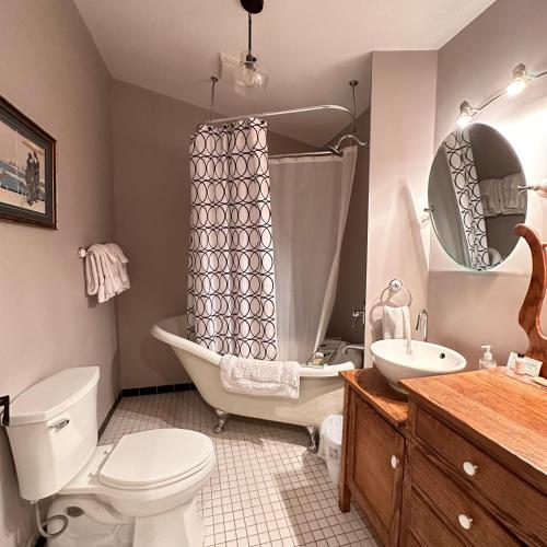 a bathroom with a tub and a toilet and a sink at Colemore Hotel in Coleman