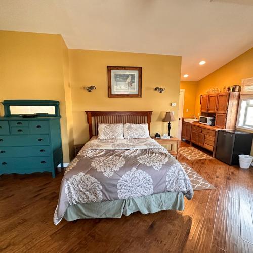 a bedroom with a bed and a blue dresser at Colemore Hotel in Coleman