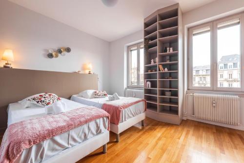 une chambre avec deux lits et une étagère dans l'établissement Nouveau - Faubourg National - En face de la Gare, à Strasbourg