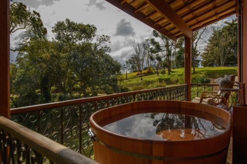a hot tub on a deck with a view at Quinta dos Pinhais Pouso e Charme in Santo Antônio do Pinhal