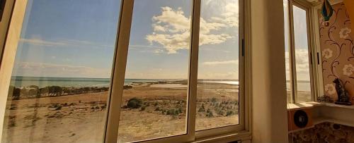 una ventana en una habitación con vistas al océano en Hergla Sea view apartment & room en Harqalah
