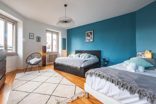 une chambre avec deux lits et un mur bleu dans l'établissement Nouveau - Faubourg National - En face de la Gare, à Strasbourg