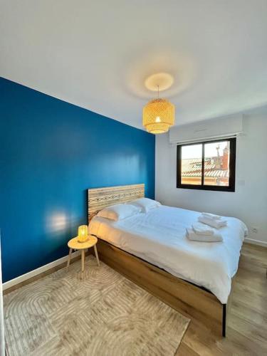une chambre avec un mur bleu et un lit dans l'établissement Charmant T3 - Palais de Justice, à Toulouse