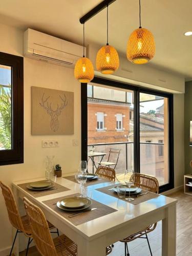 - une salle à manger avec une table, des chaises et des lumières dans l'établissement Charmant T3 - Palais de Justice, à Toulouse