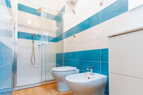 a blue and white bathroom with a toilet and a sink at Piazza Tasso Suite in Sorrento