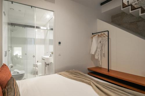 a white bedroom with a shower and a bed at Bandeiras in Porto