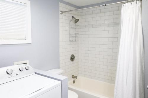 a white bathroom with a tub and a toilet at The Main Nest - Near City Center in Klamath Falls