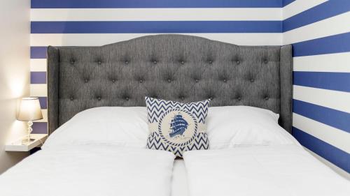 a bed with a blue and white striped wall at Apartament na Bałtyckiej 6 in Kołobrzeg
