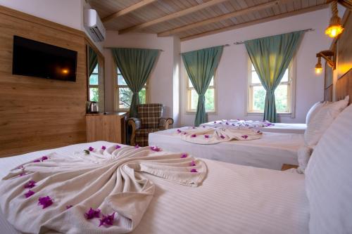 a hotel room with two beds with flowers on them at Museum Resort Spa in Bodrum City