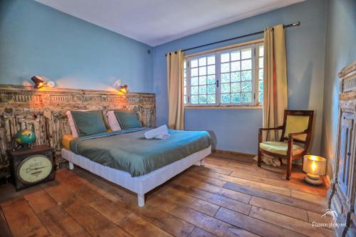 um quarto com uma cama, uma cadeira e uma janela em CASA-Villa Grinnell em Grasse