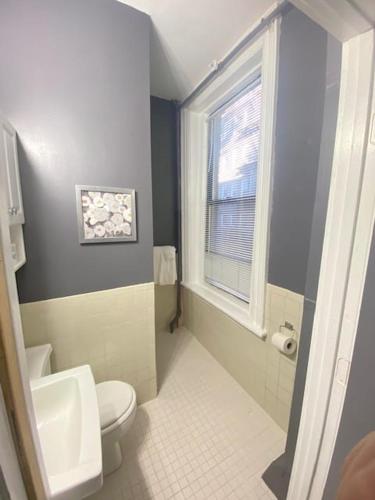 a bathroom with a white toilet and a window at Premier Suites Bay Village in Boston