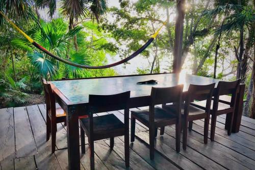 una mesa de madera y sillas en una terraza de madera en Cabañas Sukha Bacalar, en Bacalar