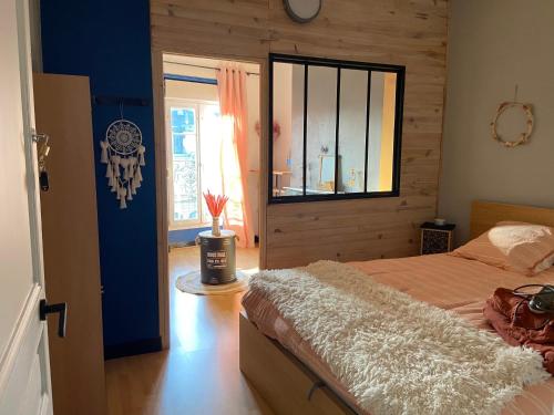 ein Schlafzimmer mit einem großen Bett und einem Fenster in der Unterkunft Maison de ville au centre de Fismes in Fismes