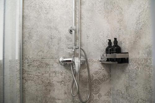 a shower with two bottles on a shelf in a bathroom at Mazzini's Rooms in Modena
